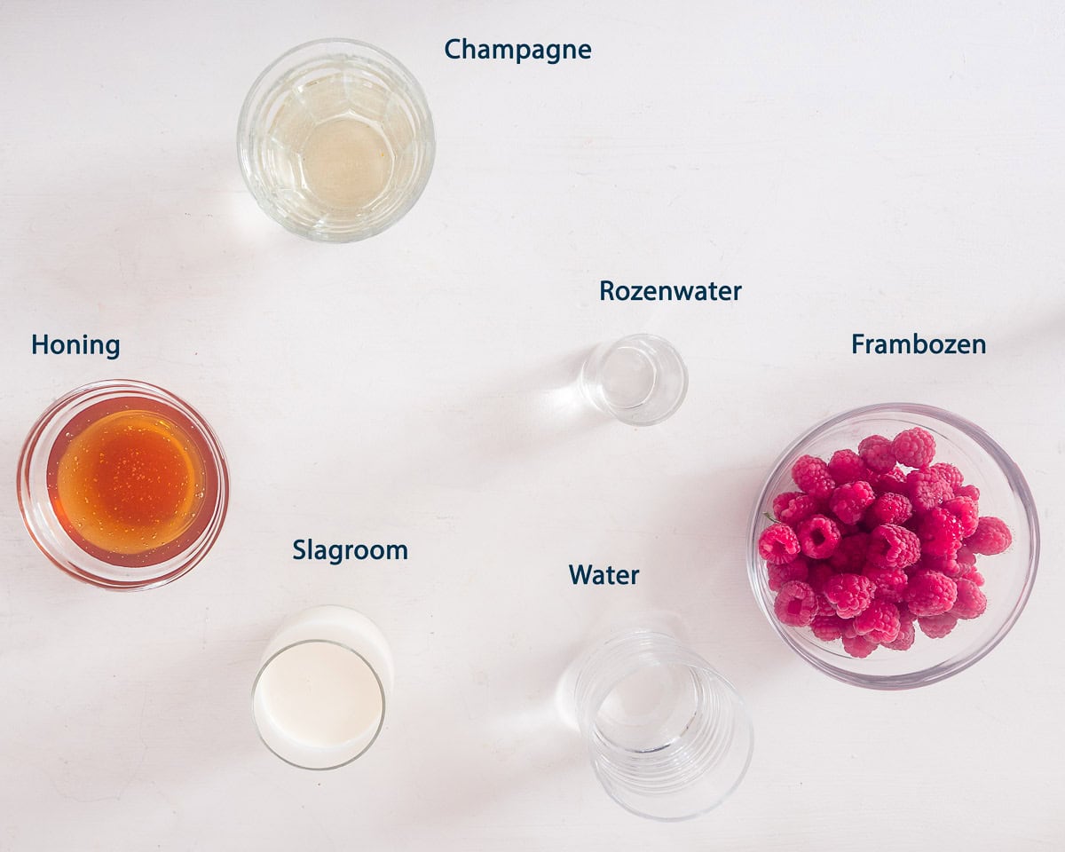 Ingredienten Champagne Cocktail met Frambozen IJslollie op een witte ondergrond met tekstbeschrijving
