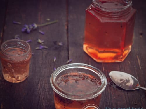 A square photo with 3 jars of apple jam on a dark background