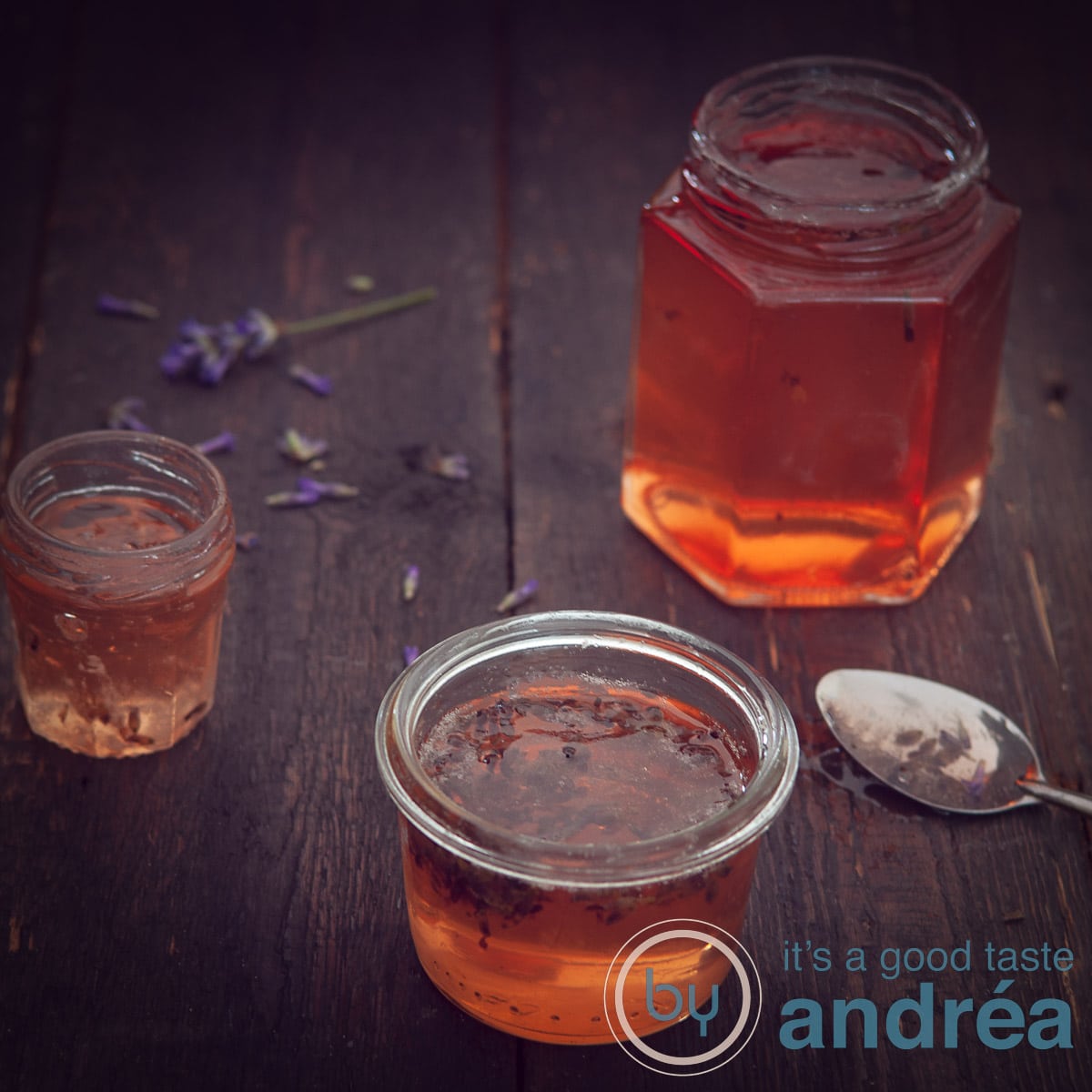 A square photo with 3 jars of apple jam on a dark background