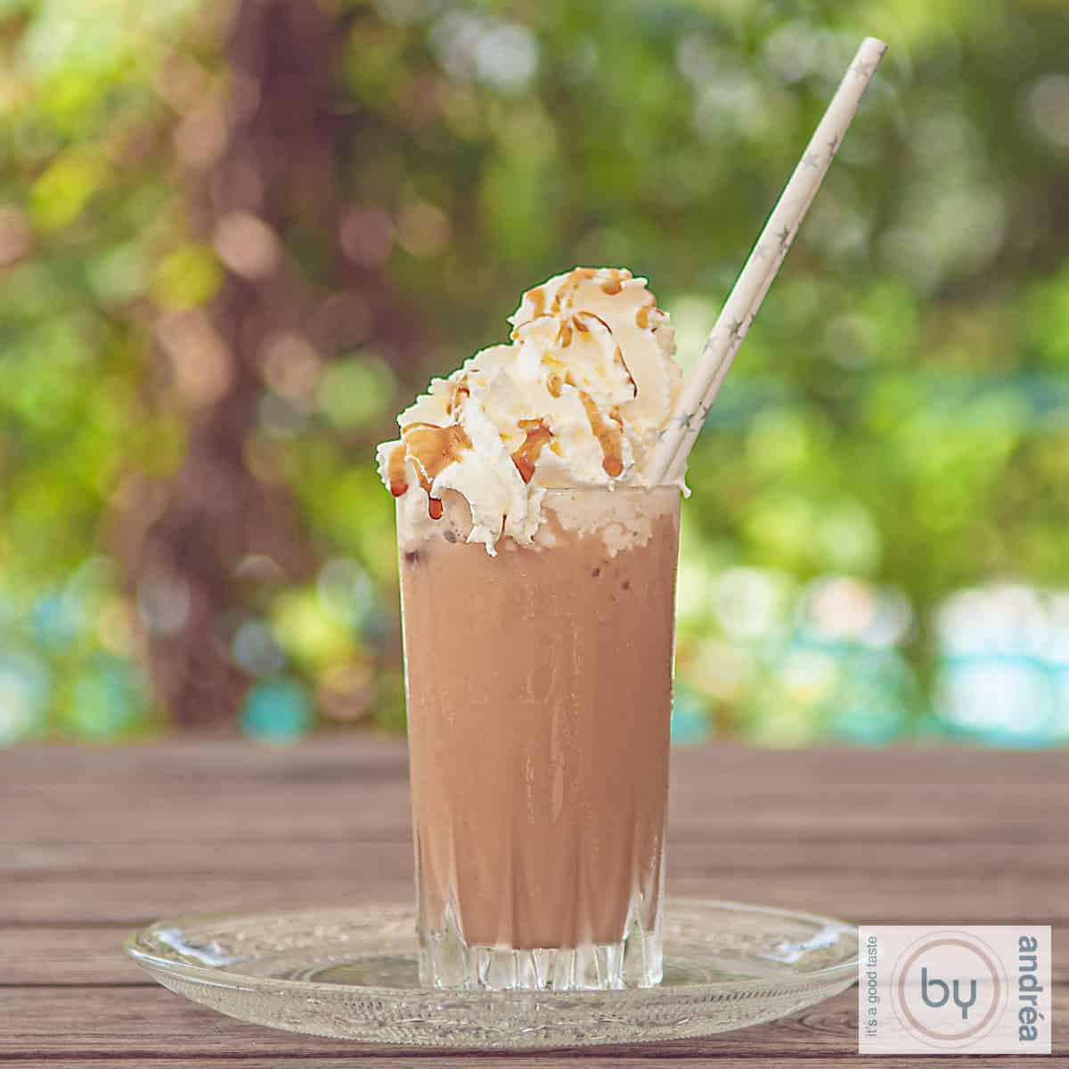 Easy Homemade Starbucks Caramel Frappuccino 3 A square photo of a frappuccino on a wooden table.