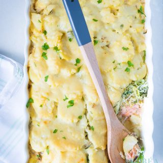 top view white casserole dish with salmon, leek and potato