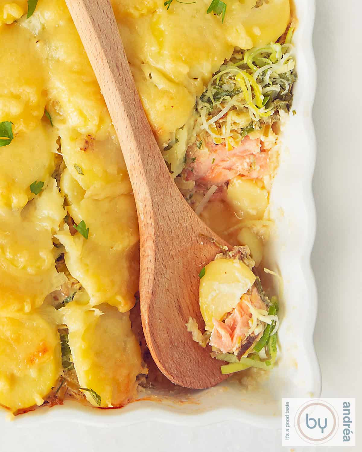 A portion of a white casserole with salmon, leek and potato with gratinated cheese
