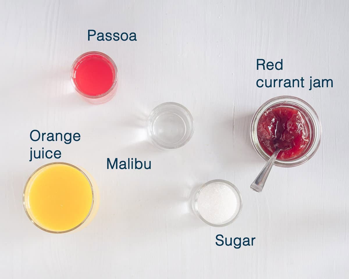 Ingredients Halloween Cosmopolitan Cocktail with Passoa and Malibu on a white background with text description