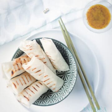 a bowl with cheese and cauliflower lumpia's. A small bowl with some dill honey mustard in the corner