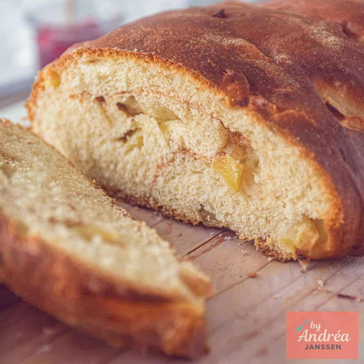 A square photo of an apple bread with a slice cut off and you can see the inside