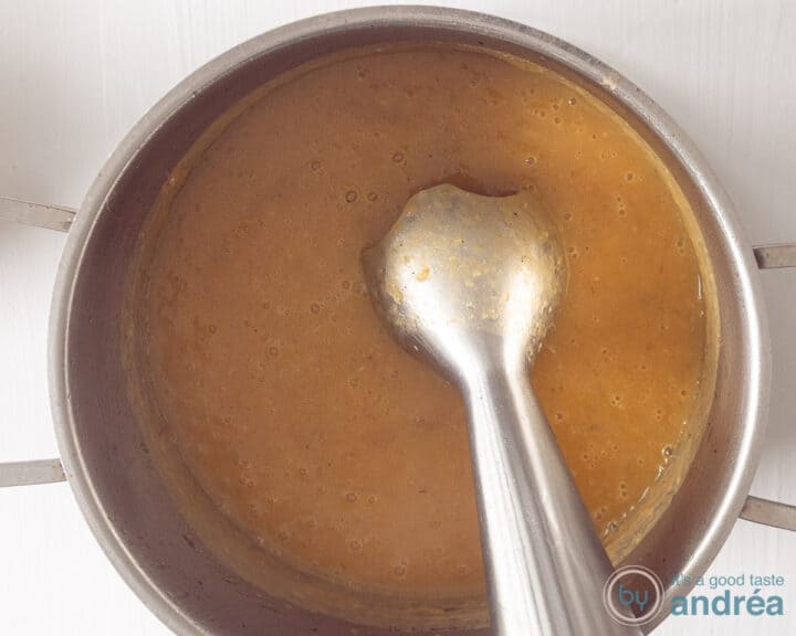 The pumpkin soup is pureed with a hand blender.