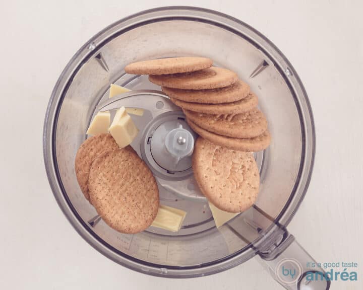 A food processor bowl with cookies and white chocolate.