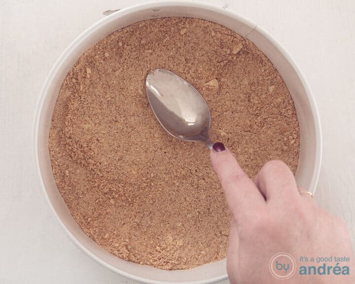 Place the crumbled cookie chocolate mix in the springform pan and smooth it out with the rounded side of a spoon.