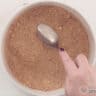 Place the crumbled cookie chocolate mix in the springform pan and smooth it out with the rounded side of a spoon.