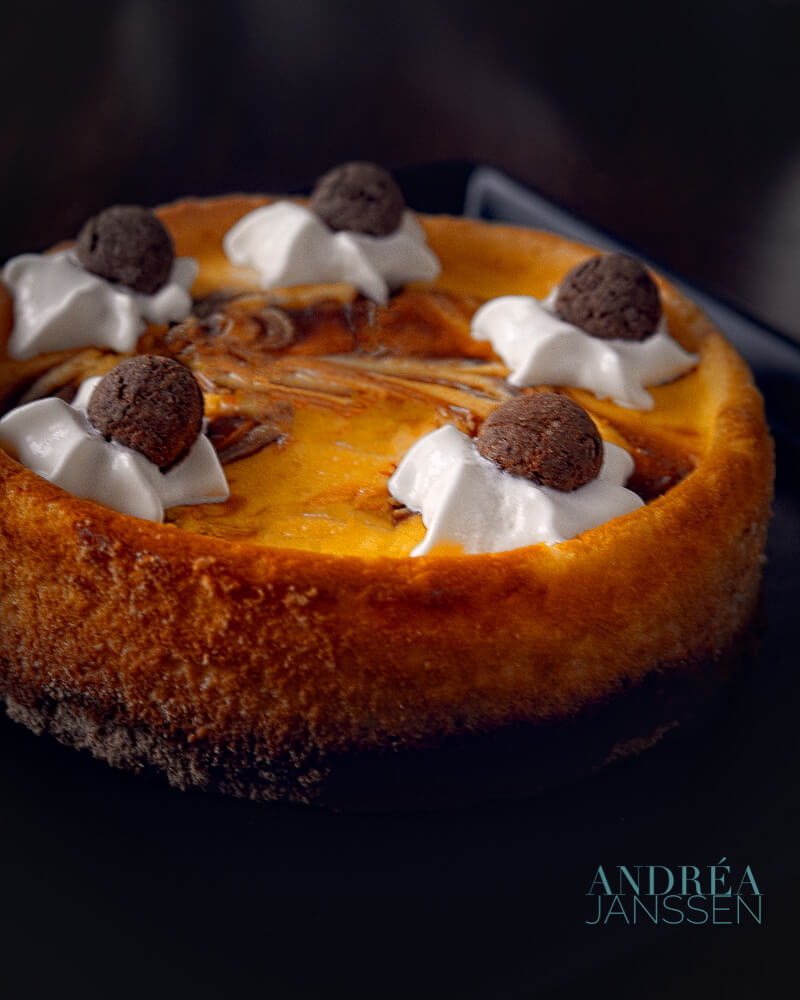a speculoos cheesecake with dots of whipped cream and pepernoten