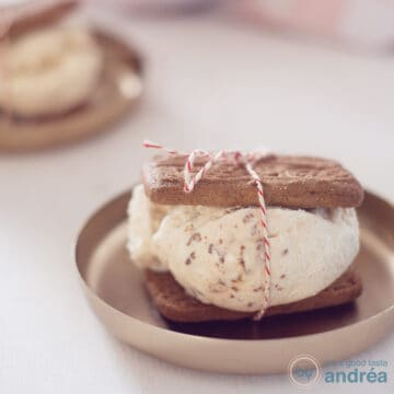 A square photo with gingerbread ice cream between two gingerbread cookies on a gold plate.