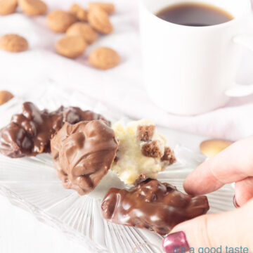 Three different kinds of pepernoten chocolate on a white backdrop with pepernoten around them and a cup of coffee in the back