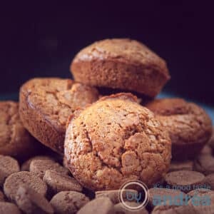 A square photo with four gingerbread cupcakes on a gingerbread bed. A black background.