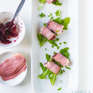 three amuse-bouche with duck breast filet, cranberry compote on a bed of arugula
