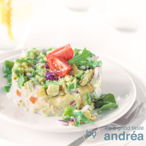 A square photo of a salad of smoked chicken and avocado on a white plate, topped with quartred cherry tomatoes on a white background
