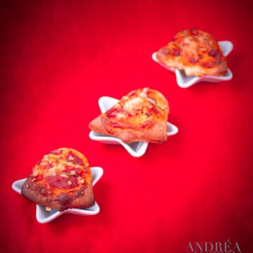 three Christmas pizza on a small plate on a red background