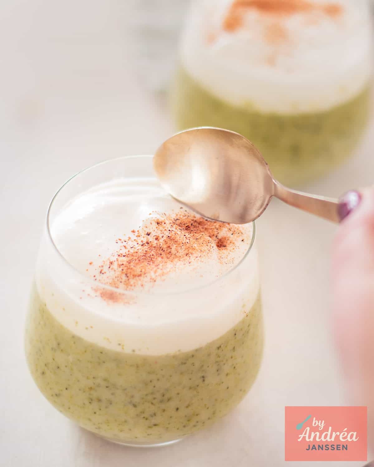 Creamy Broccoli Cappuccino in a Glass, a spoon takes a bite.