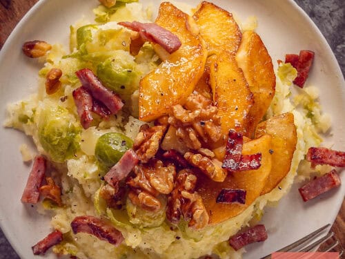 A square photo with a plate full of Creamy Brussels Sprouts Mash with Apple and Bacon