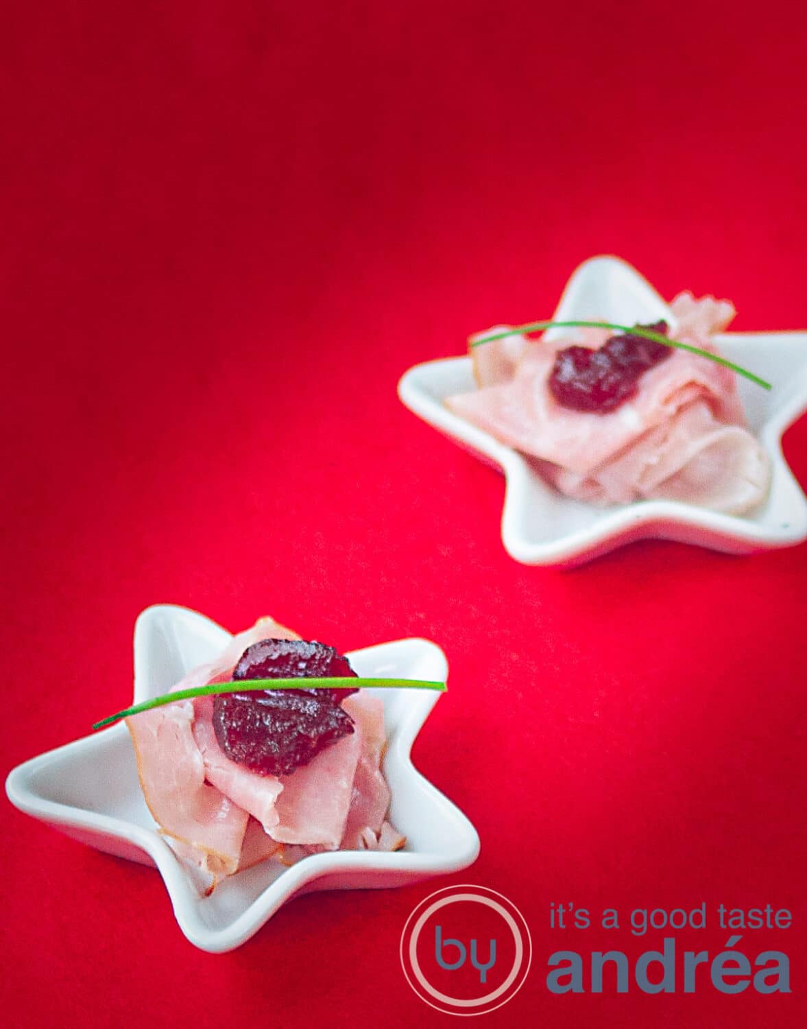 2 small plates with ham and cranberry on a red carpet