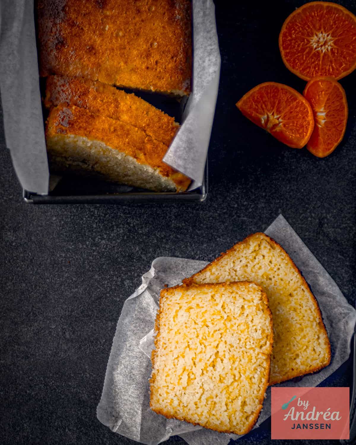 Mandarijn cake op zwarte ondergrond, twee plakjes afgesneden.