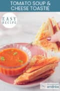 A photo of a pink plate with a bowl of tomato soup, a toasted sandwich with melted cheese next to it. A caption at the top reads: easy recipe, Tomato Soup & Cheese Toastie