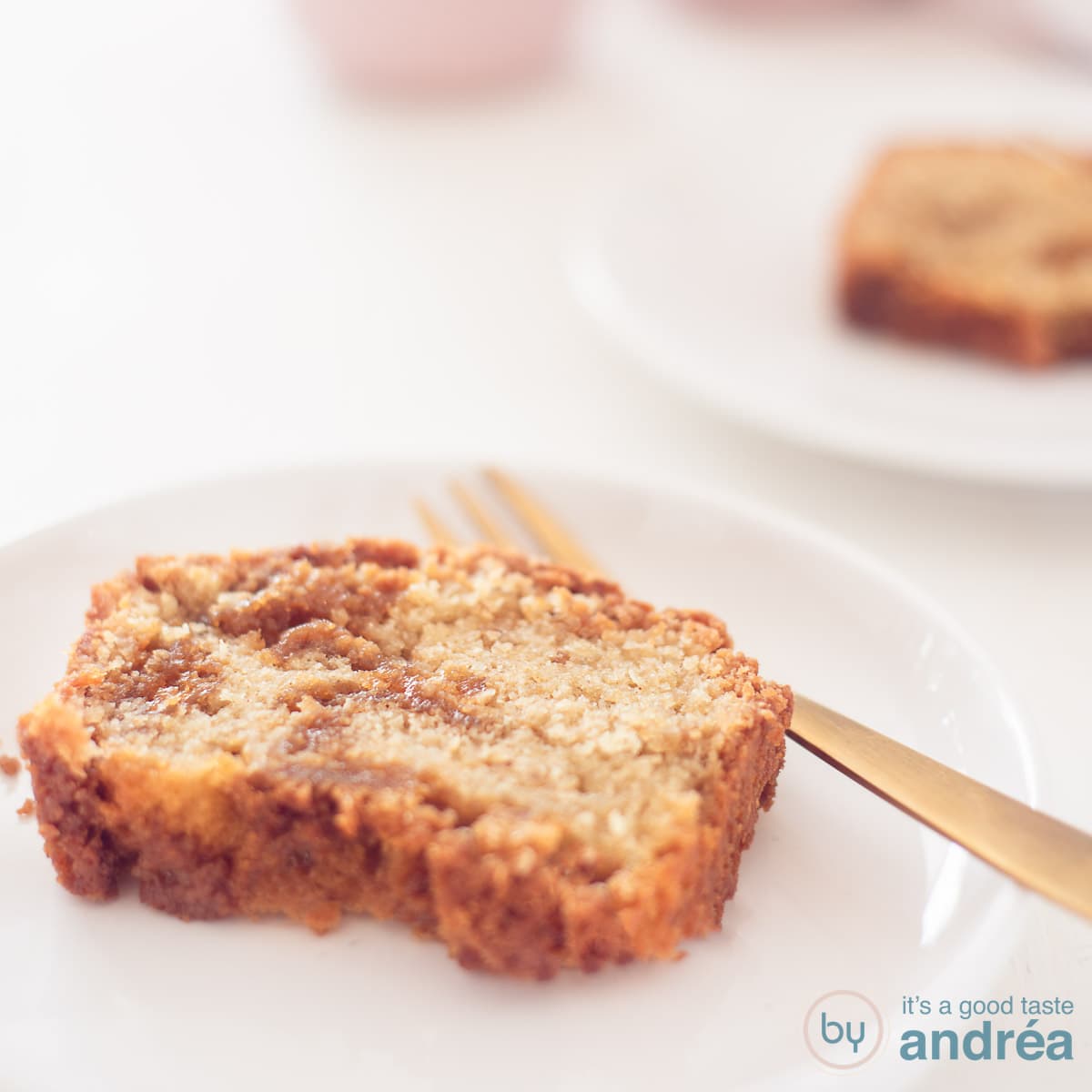 A square photo with two plates with a slice of stroopwafel cake on a white background.