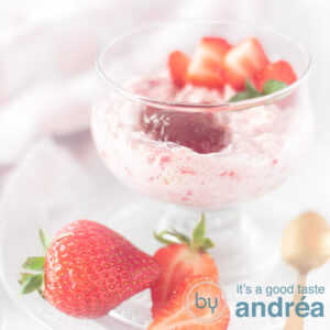 Square photo of strawberry mousse with oatmeal in a glass with a topping of fresh strawberries (these are also in front).