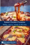 Baked chicken pizzaiola with melted mozzarella cheese pull in a baking dish, close-up shot