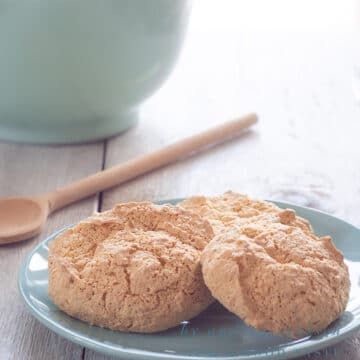 Three sponge cookies on a blue plate with a blue bowl in the background