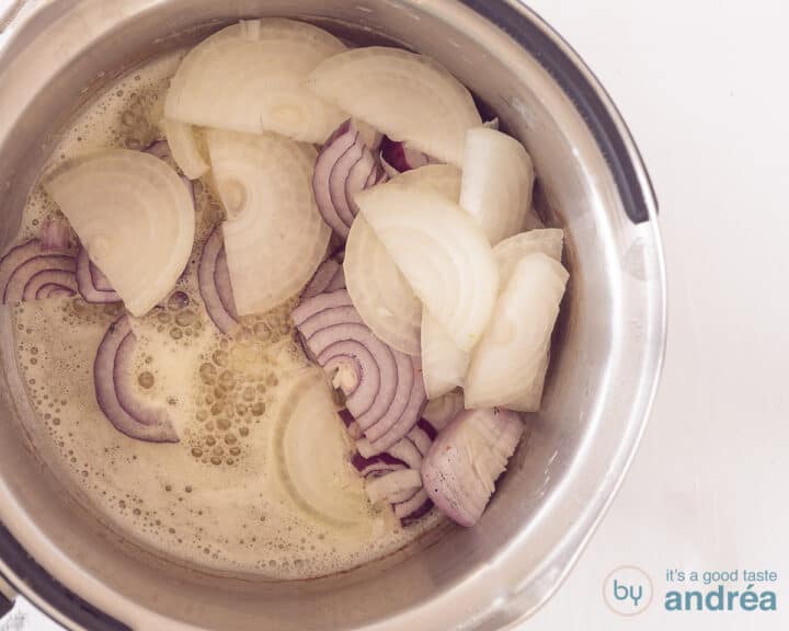 A saucepan filled with red and white onion rings.