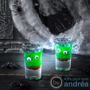 Een vierkante foto met twee glazen gevuld met non alcholische halloween drank met twee oogjes en een rood mondje