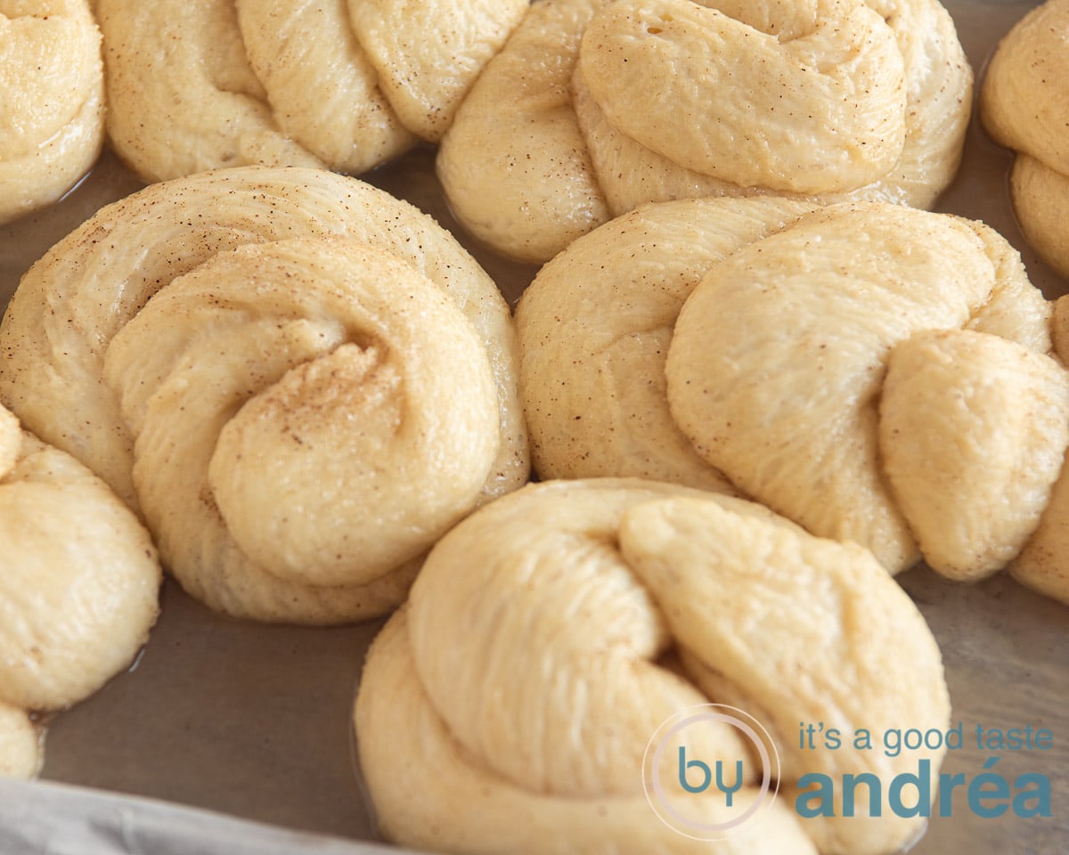 Dough on a baking tray that is rising. The dough is formed into a knot.
