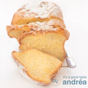 A square photo with a golden yellow cake with a slice cut off on a white background