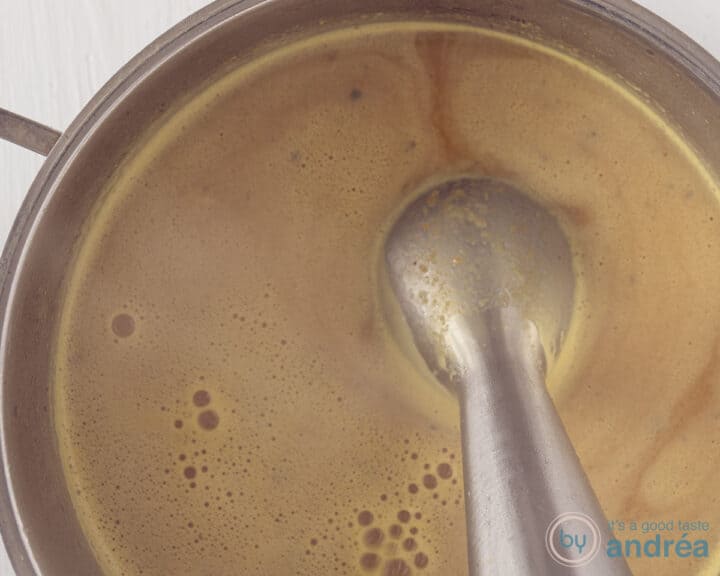 An immersion blender in the pan that purees the soup.