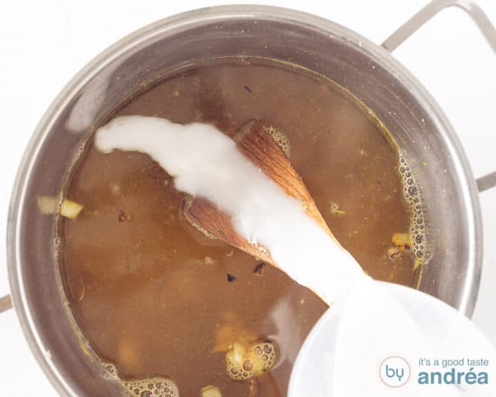 Coconut milk is poured into the soup pot.
