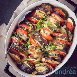 a square picture of an ovendish filled with roasted slices of vegetables, herbs and cheese gratin.