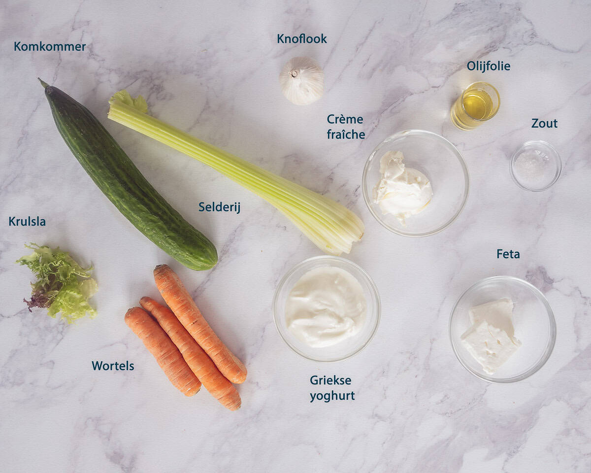 Ingredienten Maak Romige Feta Dip Met Griekse Yoghurt op een marmeren ondergrond met tekstbeschrijving