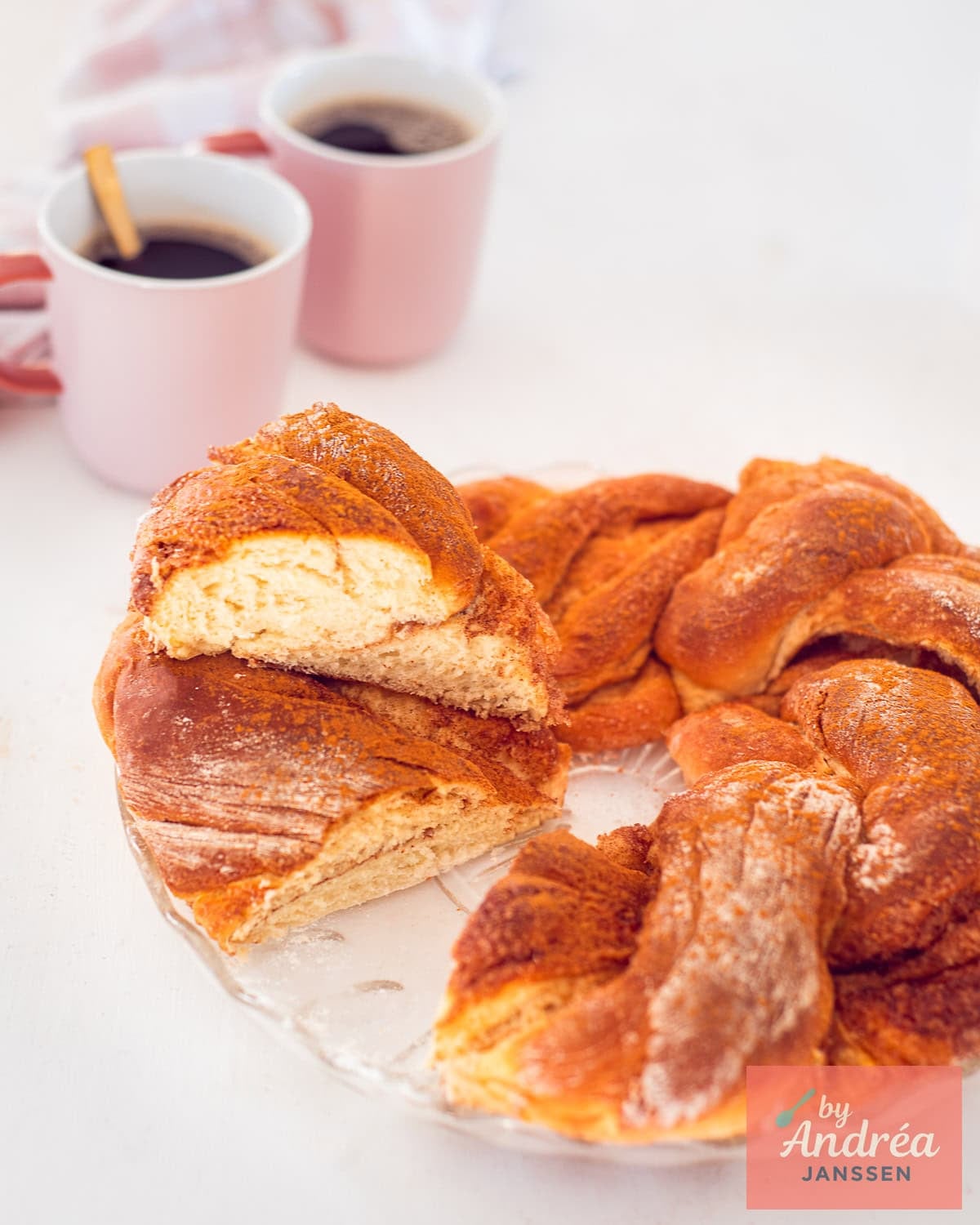 A bread wreath with cinnamon. A piece sliced off and placed on top.