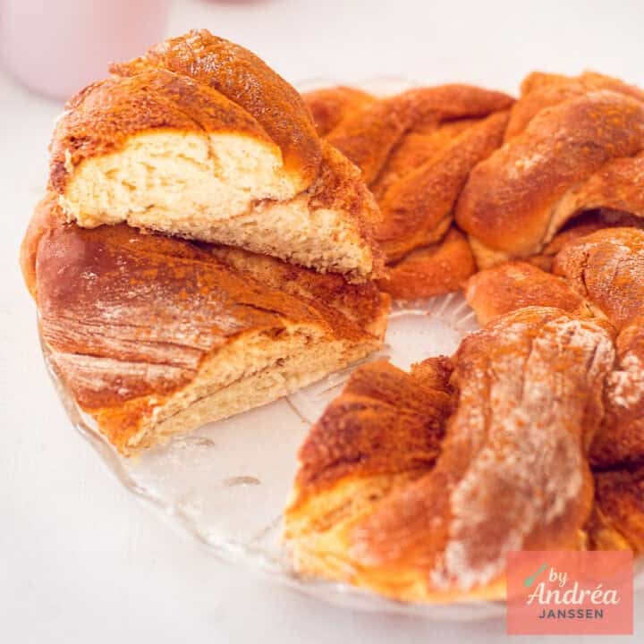 Square picture with part of a cinnamon wreath bread. A slice cut out and placed on top.