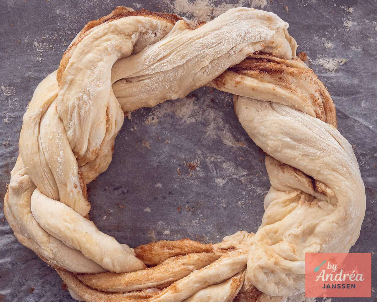 Cinnamon bread dough on a baking plate in a wreath form.