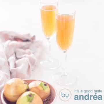 A square photo with two glasses filled with pear champagne cocktail. In the foreground, on the left, a dish with stewed pears.