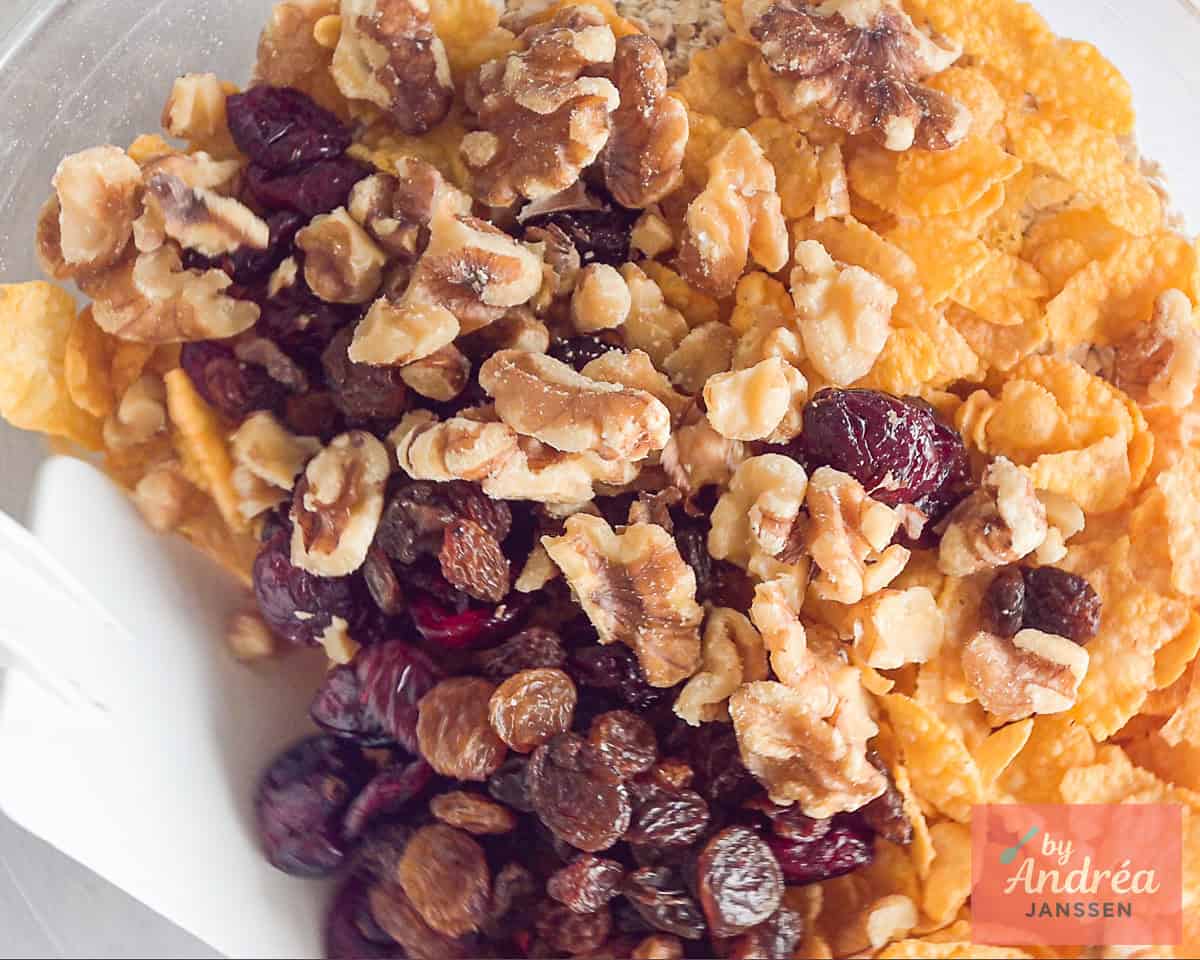 A bowl with dried fruits, oats, cornflakes and walnuts
