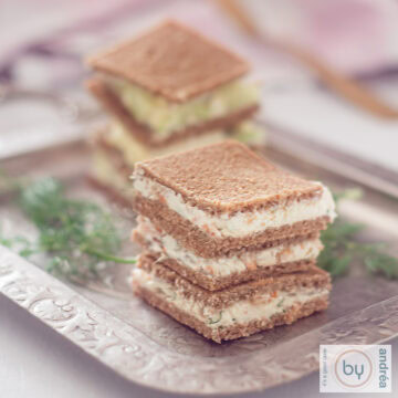 A square picture with a silver plate with a staple of rye bread sandwiches filled with cream cheese salmon or cucumber.