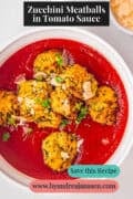 A portion of a white plate with vegetarian meatballs in tomato sauce. The text above reads: Zucchini Meatballs in Tomato Sauce.