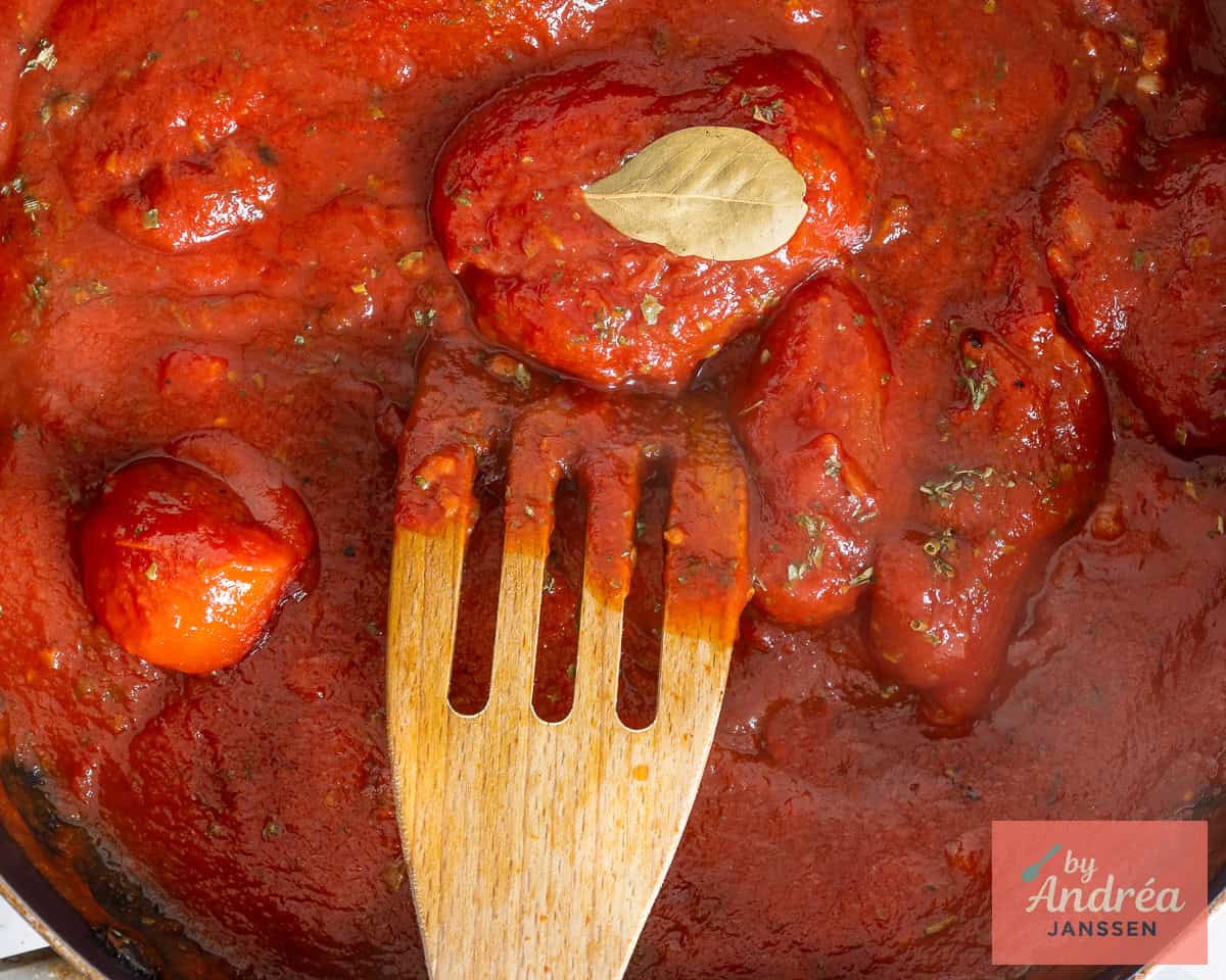 Zelfgemaakte tomatensaus met een laurierblaadje in een koekenpan