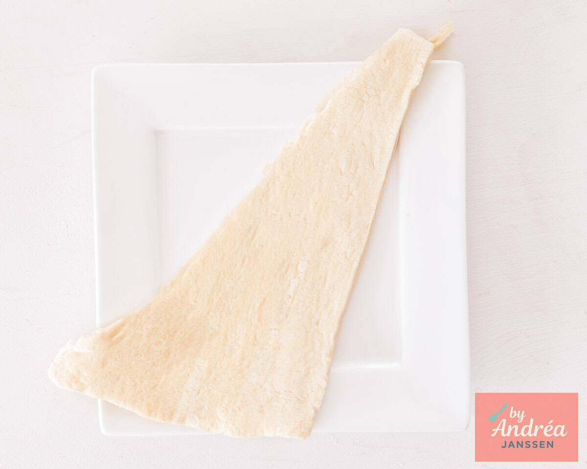 A triangle piece of puff pastry on a white plate