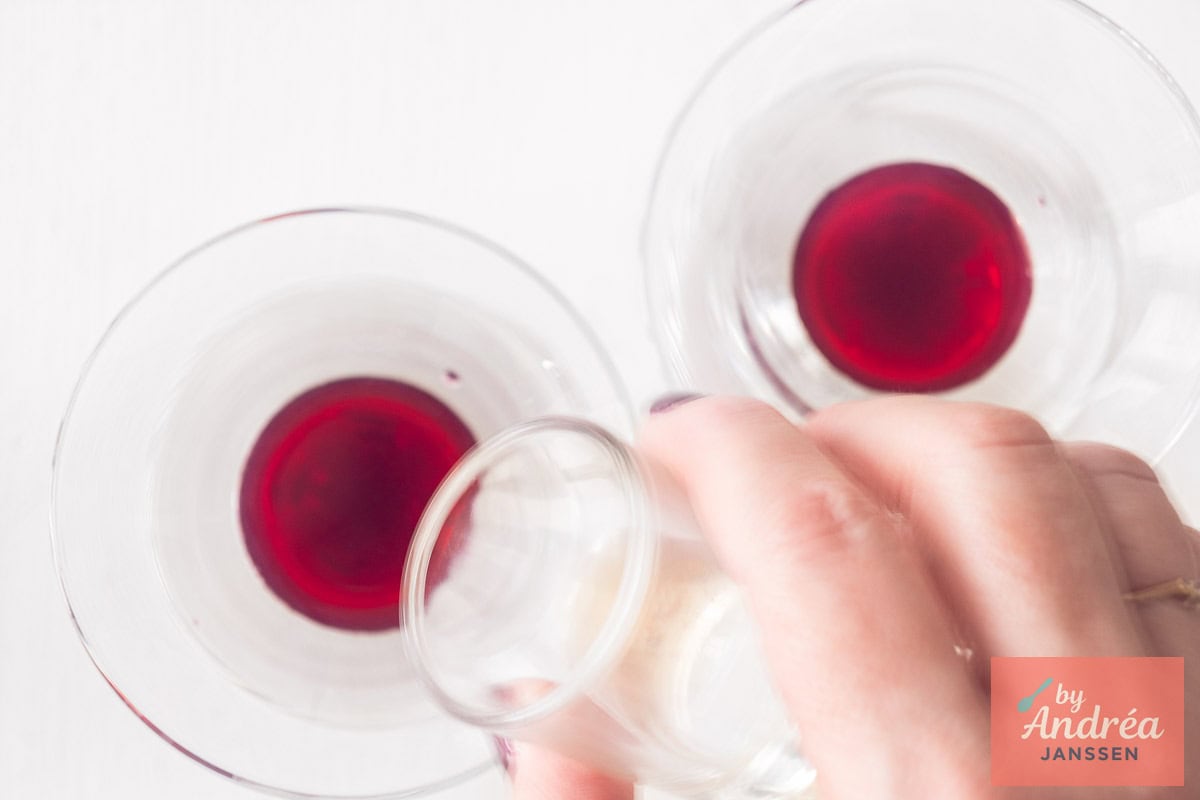 Vanilla extract is added to a glass with cherry juice