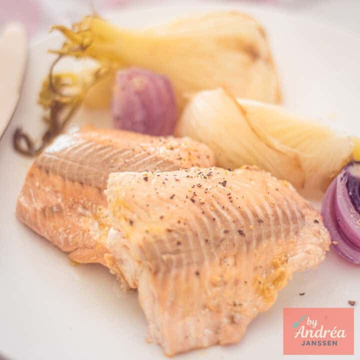 A square photo with Poached Salmon with Fennel and Orange on a white plate