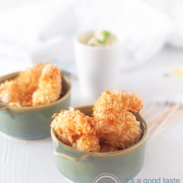 Two blue bowls filled with popcorn shrimp. Aioli dip in the background.