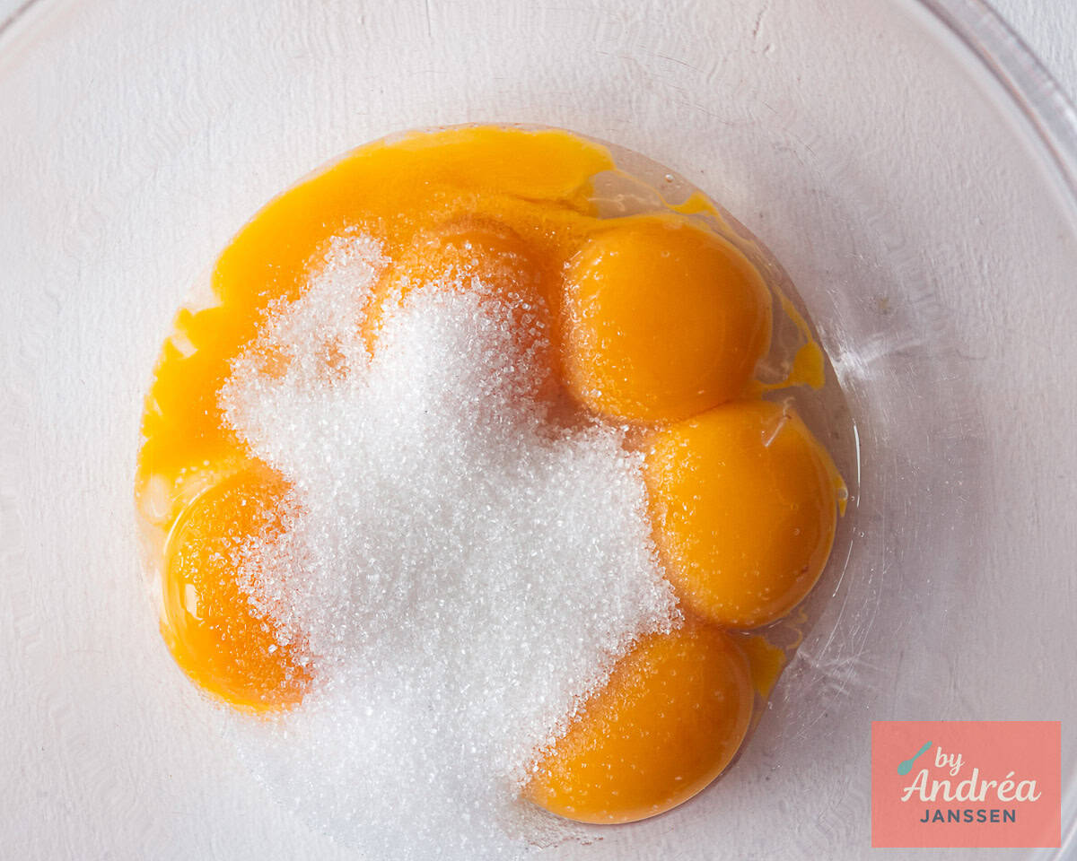 Egg yolks and sugar in a glass bowl